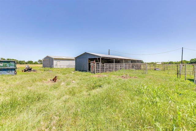 view of yard with a rural view and an outdoor structure