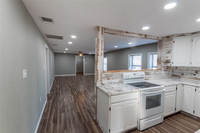 kitchen featuring electric stove, dark wood-type flooring, white cabinets, backsplash, and kitchen peninsula