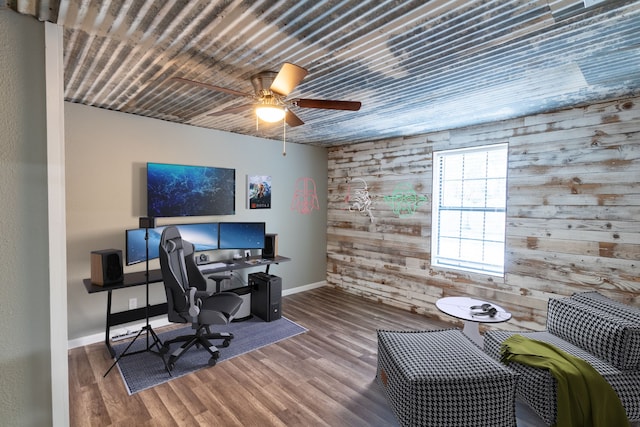 office featuring wooden walls, ceiling fan, and hardwood / wood-style flooring