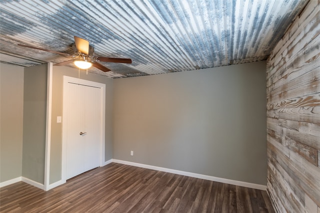 empty room featuring dark wood-type flooring and ceiling fan