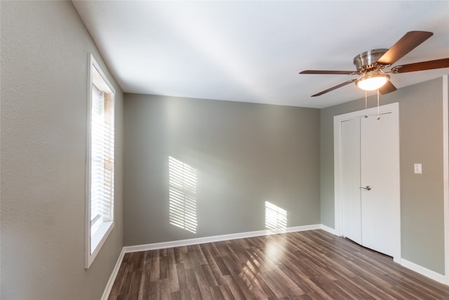 spare room with dark hardwood / wood-style floors, ceiling fan, and a wealth of natural light