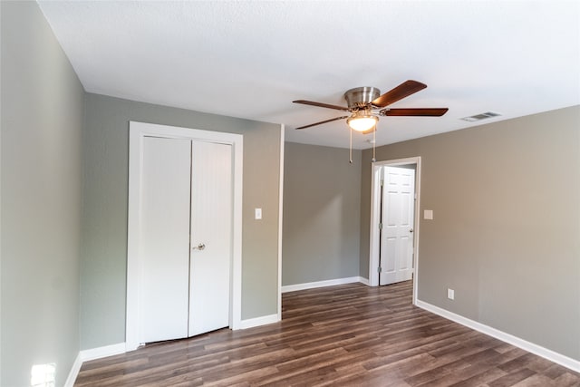 unfurnished bedroom with a closet, ceiling fan, and dark hardwood / wood-style flooring