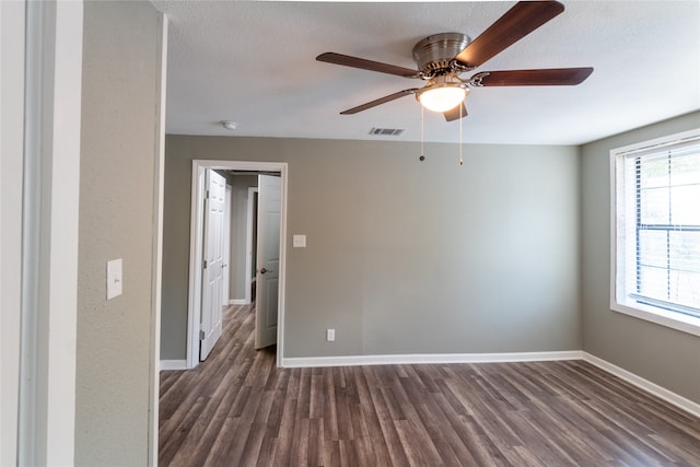 spare room featuring a textured ceiling, dark wood-type flooring, and ceiling fan