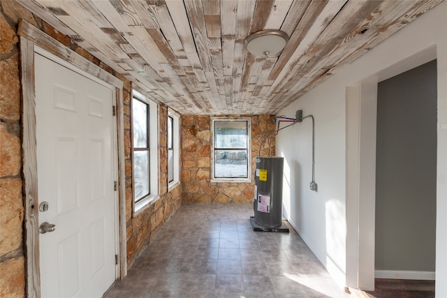 interior space with wood ceiling, electric water heater, and tile patterned floors