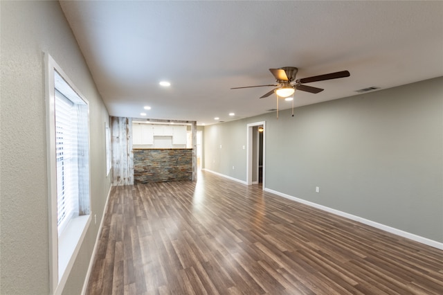 unfurnished living room with dark hardwood / wood-style flooring and ceiling fan