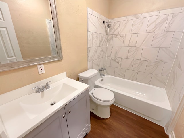 full bathroom featuring tiled shower / bath combo, hardwood / wood-style floors, toilet, and large vanity