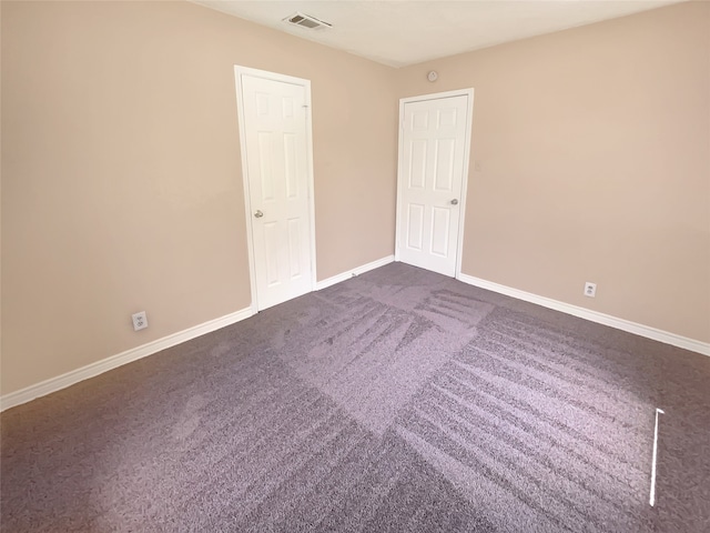 spare room with dark colored carpet