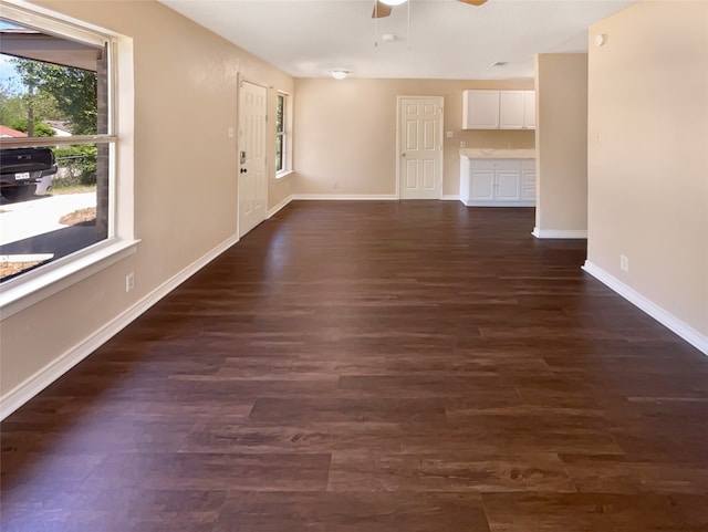 spare room with a wealth of natural light, ceiling fan, and dark wood-type flooring