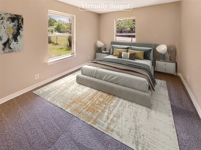 bedroom with multiple windows and dark colored carpet