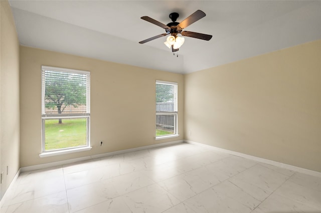 empty room with ceiling fan and light tile flooring