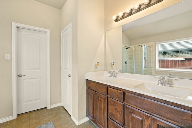 bathroom featuring tile flooring, oversized vanity, double sink, and walk in shower