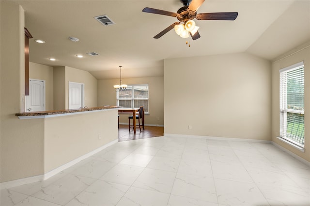 interior space with ceiling fan with notable chandelier, lofted ceiling, and light tile floors