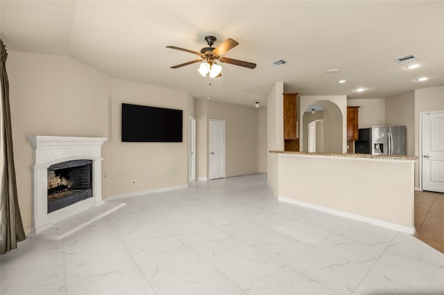 unfurnished living room with ceiling fan and light tile floors