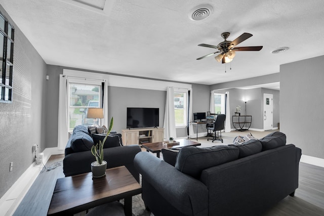 living room with ceiling fan, hardwood / wood-style flooring, and a textured ceiling