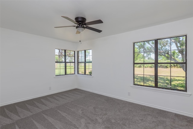 carpeted spare room featuring plenty of natural light and ceiling fan