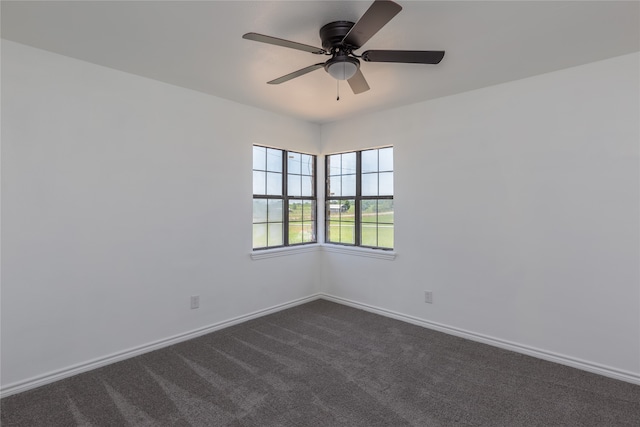 empty room featuring dark colored carpet and ceiling fan