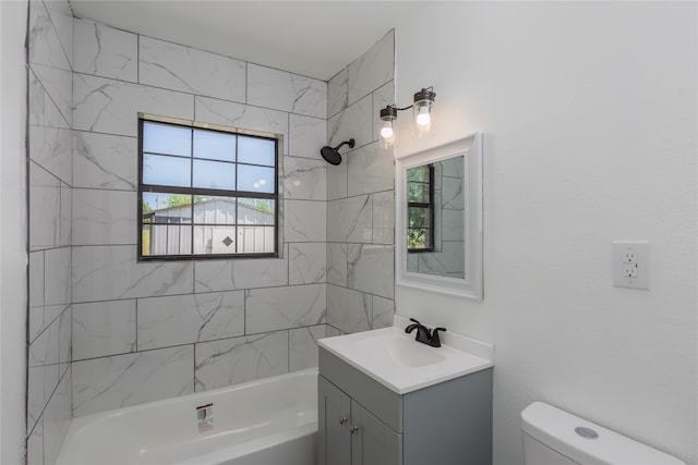 full bathroom with a healthy amount of sunlight, vanity, toilet, and tiled shower / bath