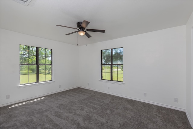 carpeted spare room featuring a healthy amount of sunlight and ceiling fan