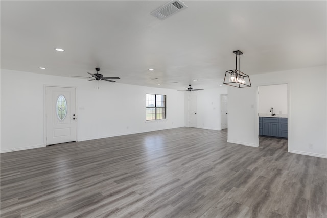 interior space featuring ceiling fan with notable chandelier, sink, and hardwood / wood-style floors