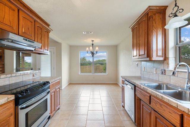 kitchen with pendant lighting, backsplash, a chandelier, appliances with stainless steel finishes, and sink