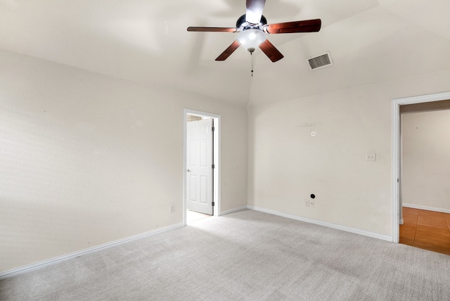 empty room with light carpet, ceiling fan, and vaulted ceiling