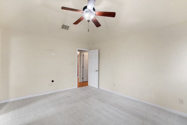 empty room with vaulted ceiling, ceiling fan, and carpet floors