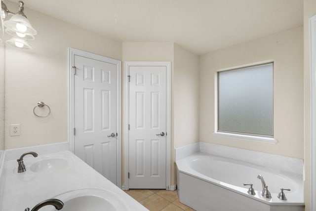 bathroom with tile floors, a bathing tub, and double sink vanity