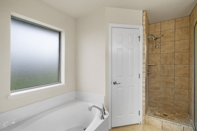 bathroom with tile floors, separate shower and tub, and a textured ceiling