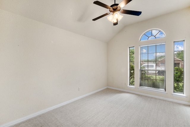 spare room featuring vaulted ceiling, a wealth of natural light, ceiling fan, and carpet floors