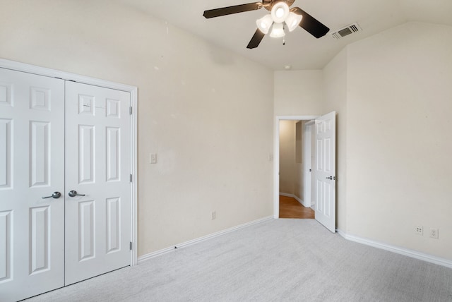 unfurnished bedroom with carpet flooring, a closet, ceiling fan, and lofted ceiling