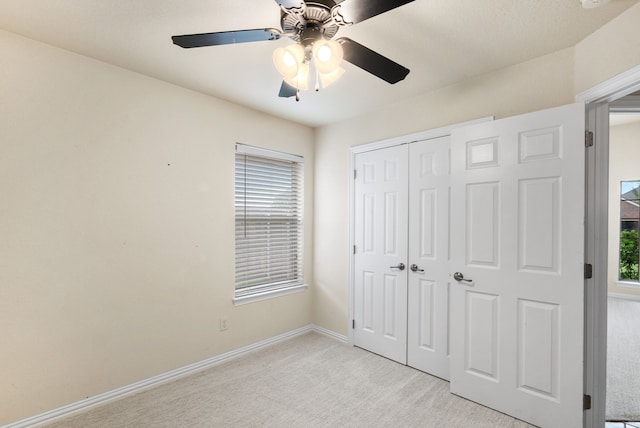 unfurnished bedroom featuring a closet, light carpet, and ceiling fan