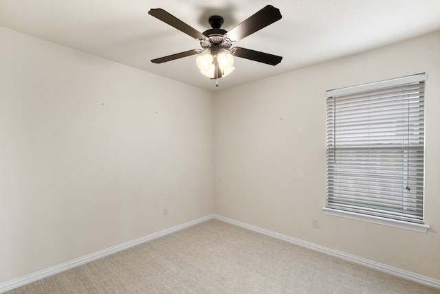 carpeted spare room featuring ceiling fan