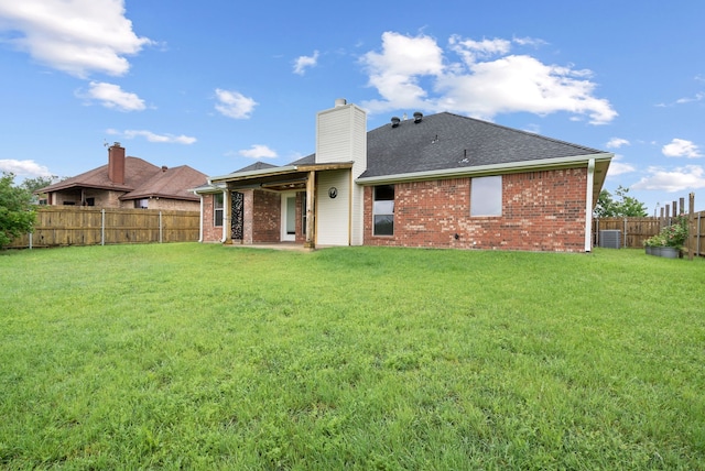 rear view of property featuring a lawn