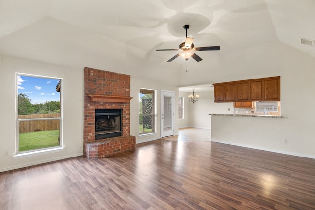 unfurnished living room featuring brick wall, a healthy amount of sunlight, and hardwood / wood-style floors