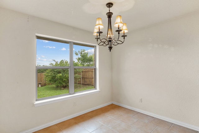 unfurnished room with light tile floors and a chandelier