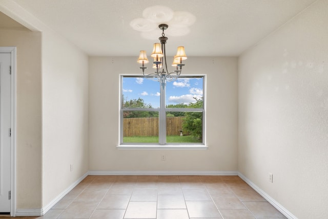 tiled empty room with a chandelier