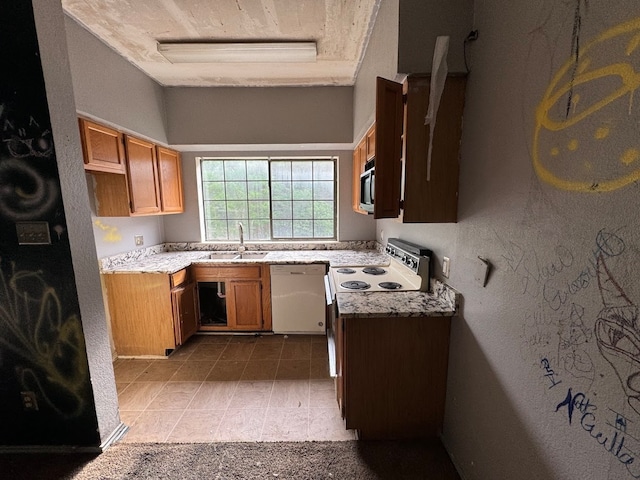 kitchen with sink, light tile floors, white dishwasher, and a raised ceiling