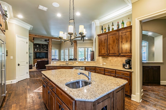 kitchen with a kitchen island with sink, hanging light fixtures, dark hardwood / wood-style floors, backsplash, and sink