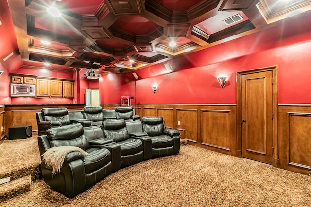 cinema room with ornamental molding, coffered ceiling, and carpet floors