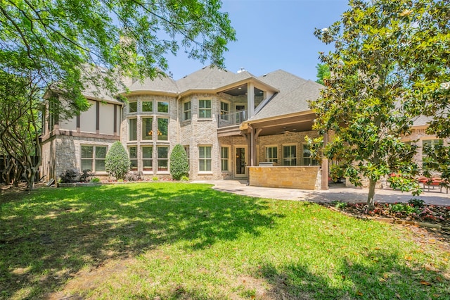 rear view of house featuring a patio area and a lawn