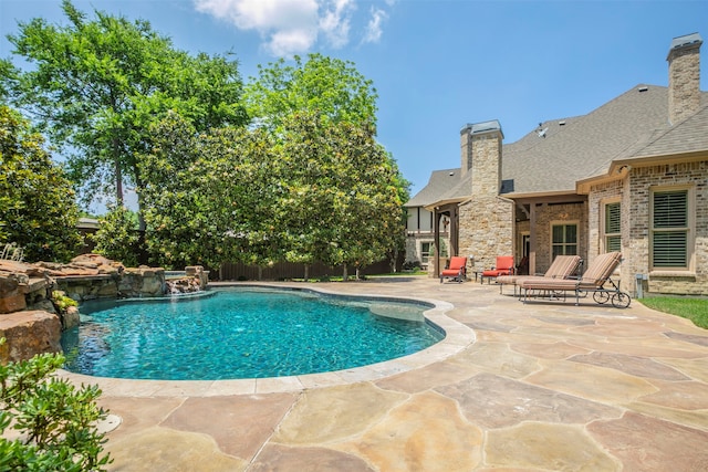 view of swimming pool featuring pool water feature and a patio area