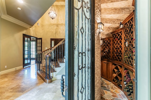 wine room featuring ornamental molding, tile flooring, and vaulted ceiling