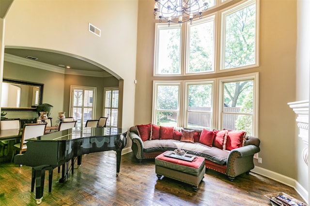 living room featuring wood-type flooring, a high ceiling, and a chandelier