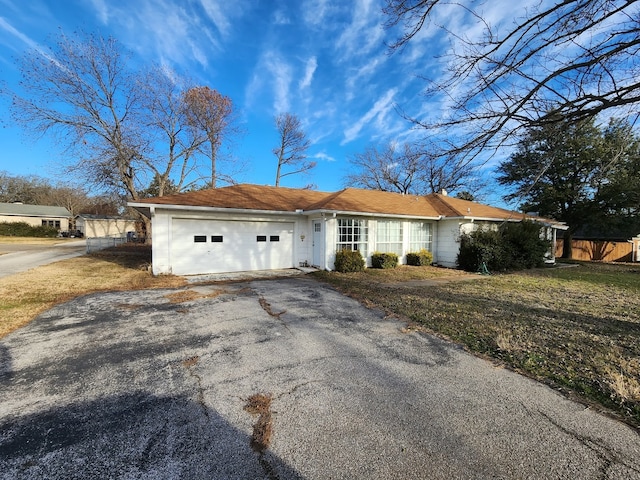 ranch-style home with a front lawn and a garage