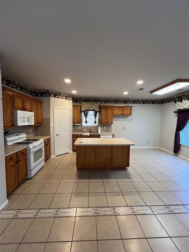 kitchen with a center island, light tile patterned floors, and white appliances