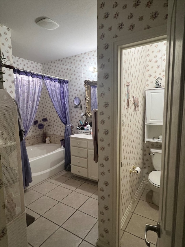 bathroom with tile flooring, vanity, a tub, and toilet