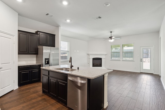 kitchen featuring appliances with stainless steel finishes, dark hardwood / wood-style floors, sink, an island with sink, and ceiling fan