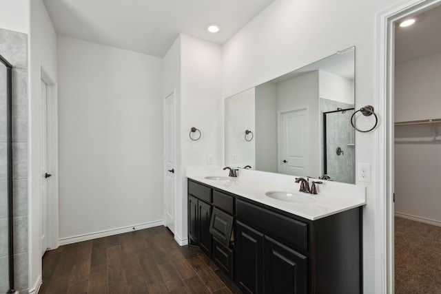 bathroom featuring double vanity, hardwood / wood-style floors, and walk in shower