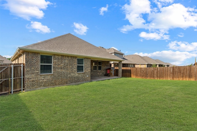 back of house with a patio and a lawn