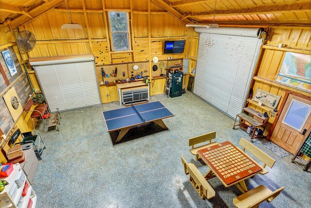 garage with wood walls, a workshop area, and wooden ceiling